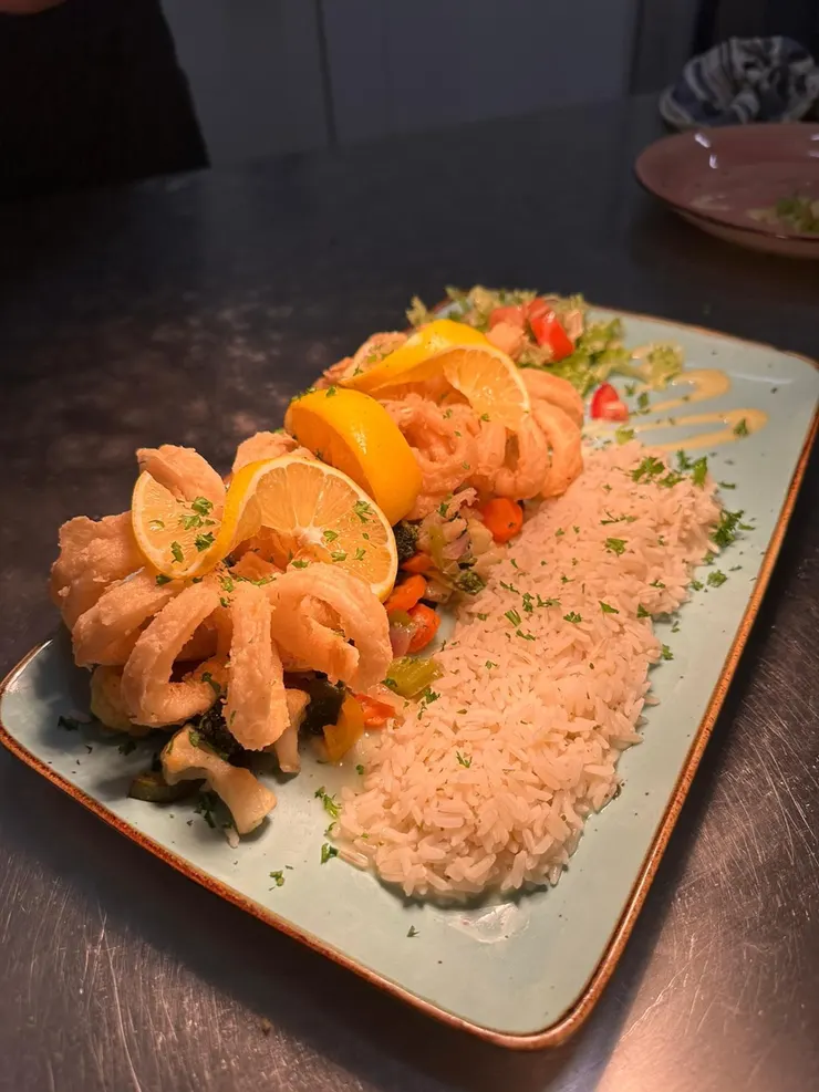 Frittierte Calamari mit Zitrone, Reis und buntem Gemüse
