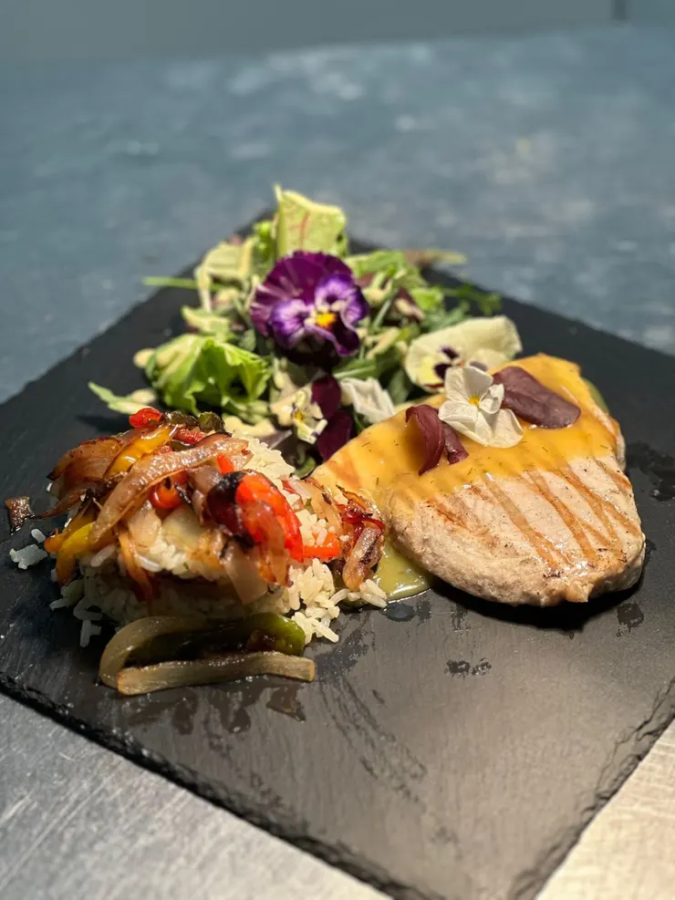 Gegrilltes Steak mit Reis, Paprika und buntem Blattsalat auf einer Schieferplatte